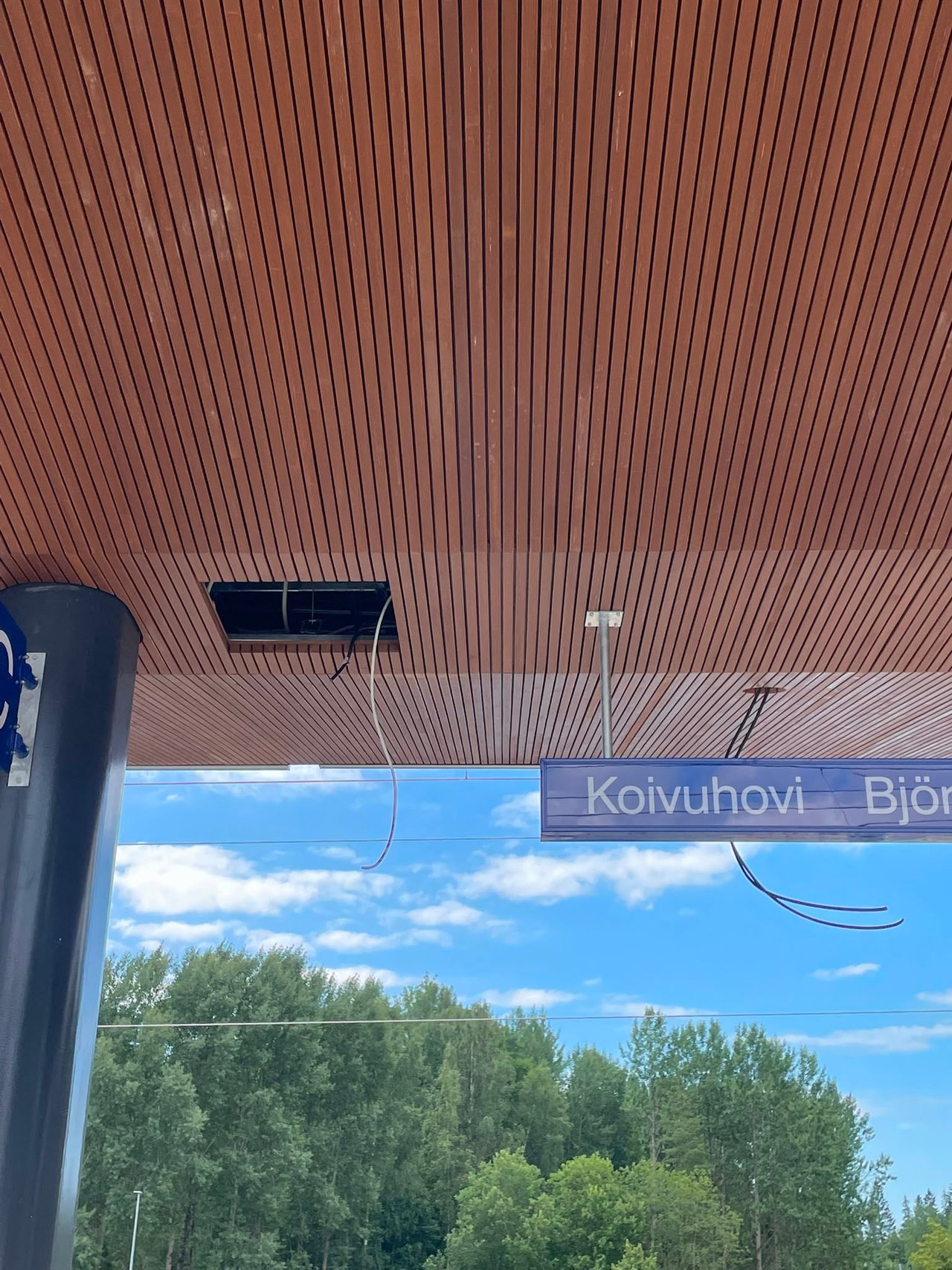 Puurimakatto lähikuvassa, taustalla Koivuhovin aseman nimikyltti